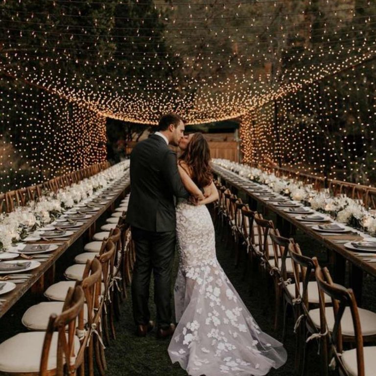 Couple kissing underneath fairy light ceiling